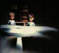 Lucas and Claus at a table, presumably at the dining table during the Prologue.